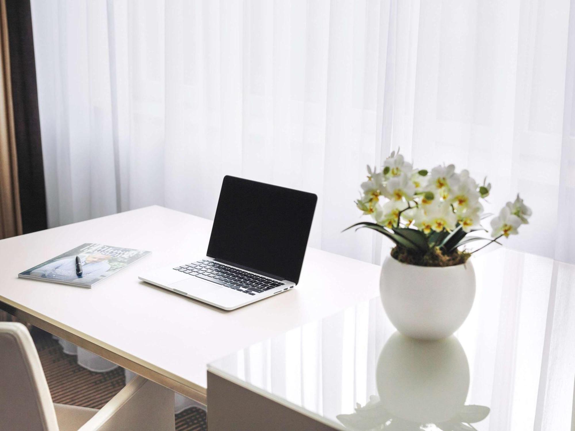 Hotel Pullman Berlin Schweizerhof Exterior foto A desk with a laptop and a vase of flowers